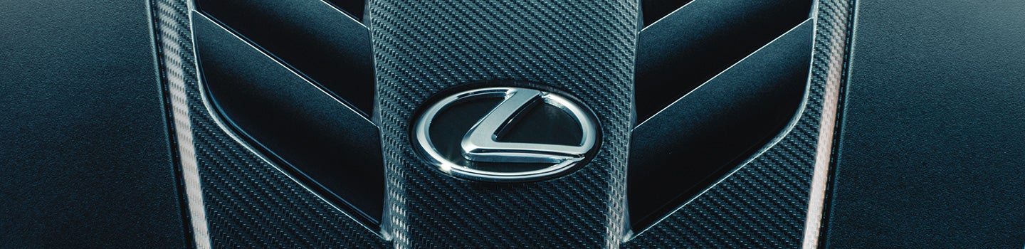 Close up of an engine featuring the Lexus emblem.